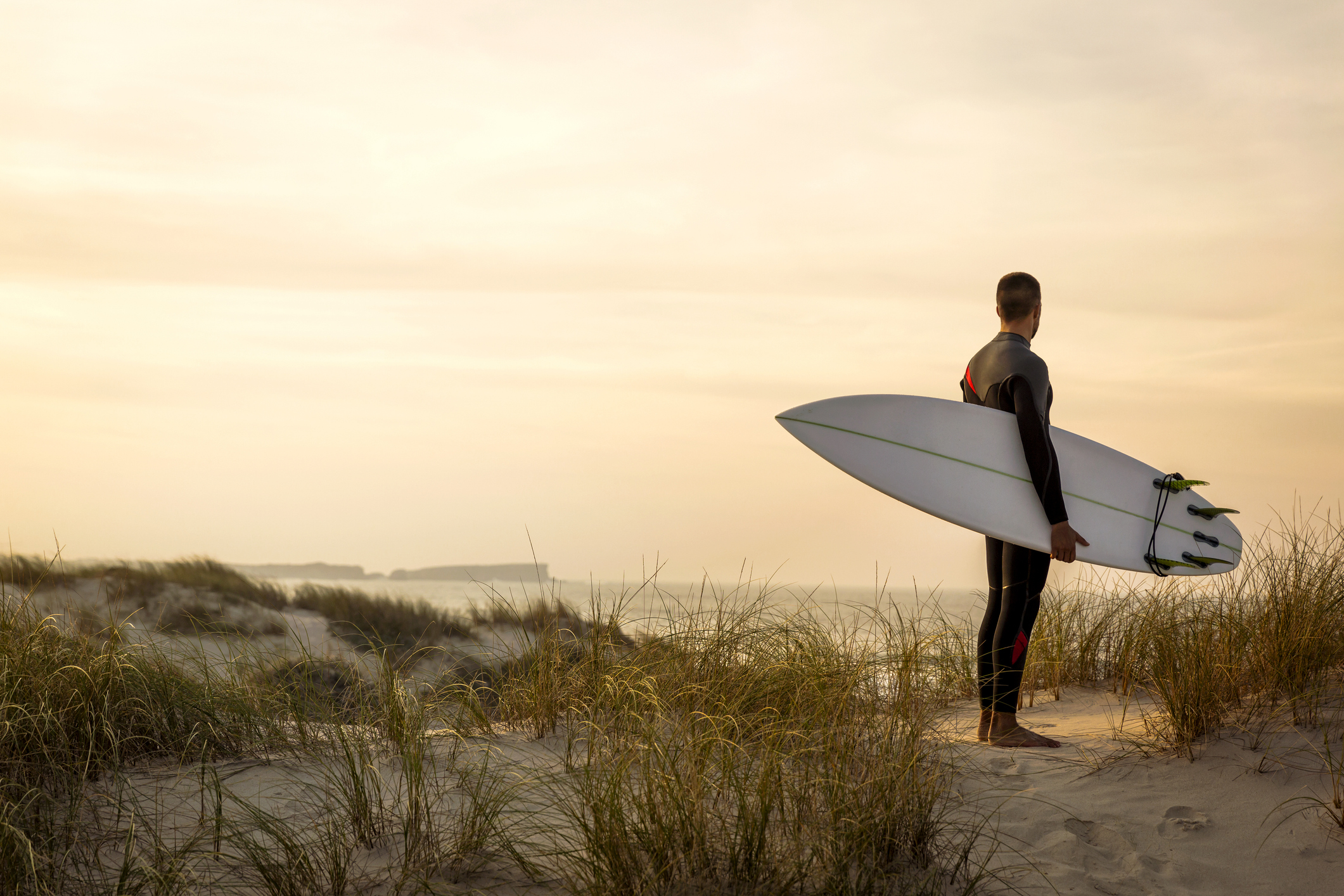 Man in Billabong wetsuit looks at surf break